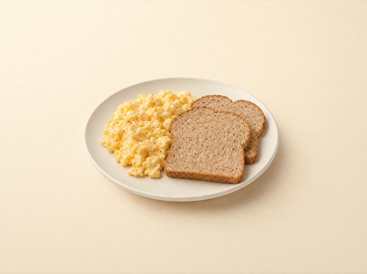 The plate: scrambled eggs with whole wheat bread.
